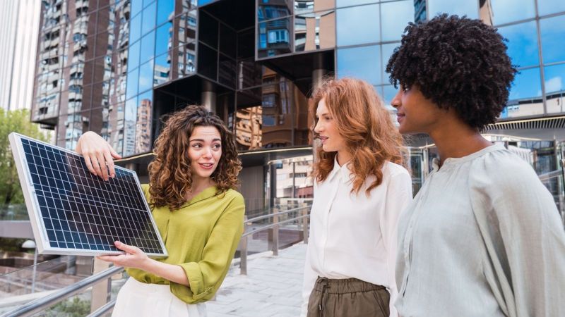 Eine Expertin erklärt zwei Passantinnen ein Solarmodul